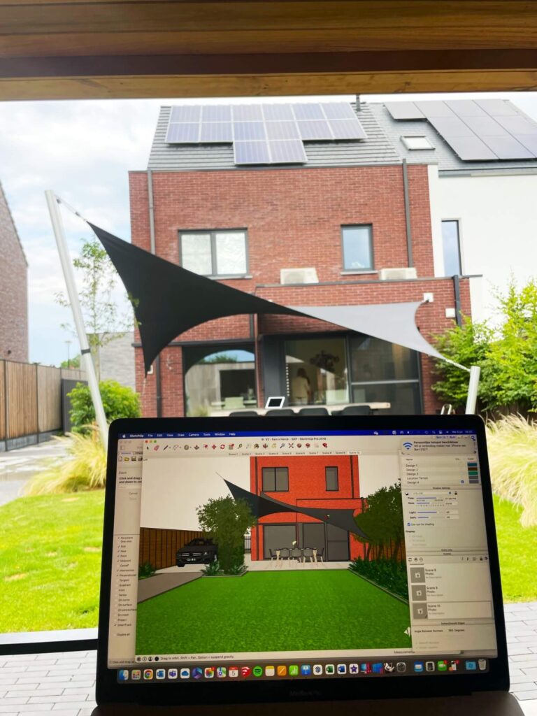 Laptop screen displaying a 3D architectural render of a red brick house with solar panels on the roof, in a sunny backyard with shade sails.