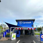 Blue car wash entrance with a large sign reading ‘Carwash’ and a height limit bar reading ‘MAX. 2,05 m’ in red and white.